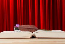 Промоција књиге „Главоломке тимочких афористичара и хумориста” у фоајеу зајечарског театра поводом 1. априла Књига, перо, мастило на столу испред позоришне завесе