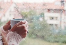 Данас облачно и кишовито Млада жена ужива у јутарњем чају и гледа кроз прозор