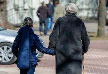 Јутро хладно, током дана претежно сунчано и топлије Старија жена са штапом и девојчица шетају улицом