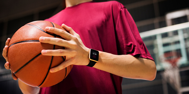 Тинејџер држи кошаркашку лопту на кошаркашком терену Тинејџер држи кошаркашку лопту на кошаркашком терену