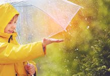 Данас претежно облачно са кишом, максимална дневна око 14 степени Дете са кишобраном у парку хвата капљице кише