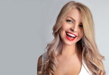 Осмех као заштитни знак Лепа девојка са црвеним кармином и блиставо белим зубима се смеје