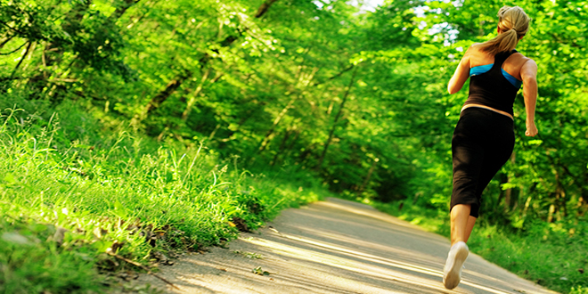 Млада девојка трчи на шумској стази