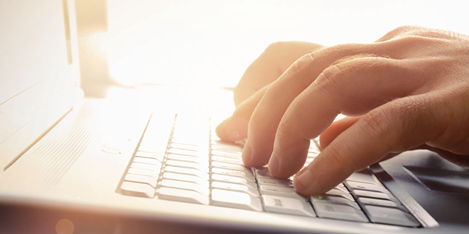 Мушкарац куца на лаптопу