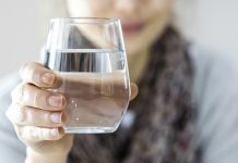 Kолико воде дневно треба да пијете Жена држи стаклену чашу са водом