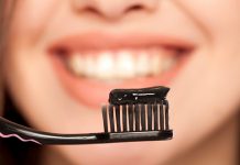 Kад сте последњи пут променили четкицу за зубе? Девојка држи црну четкицу и црну пасту за зубе