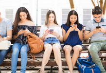 Генерација Z не користи Facebook, прешли су на Instagram и YouTube Тинејџери седе на клупи и дописују се преко мобилних телефона