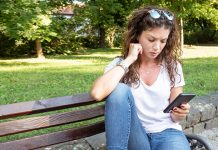 ТУЖНО: Петина младих сматра да нема НИЈЕДНОГ пријатеља Усамљена девојка седи на клупи и држи мобилни телефон