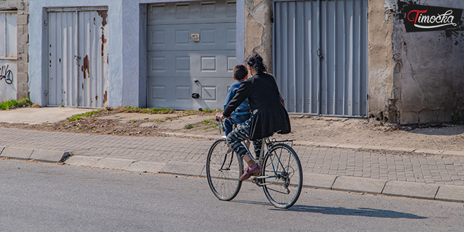Жена вози свог сина на бициклу