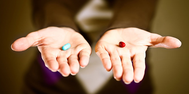 Жена држи у руци плаву и зелену пилулу