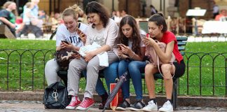 У Србији данас до 37 степени, увече стиже пролазно наоблачење Девојке седе у парку заузете својим мобилним телефонима