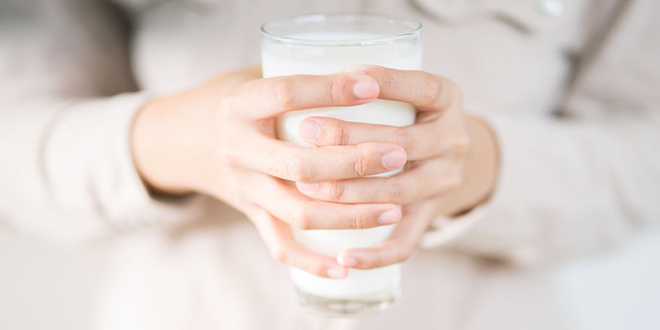 Жена држи чашу са млеком