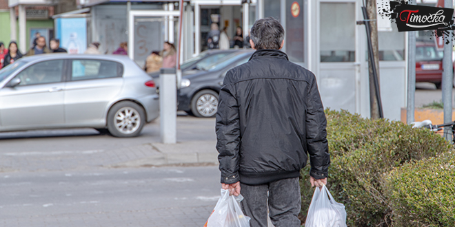 Мушкарац носи кесе из продавнице Мушкарац носи кесе из продавнице