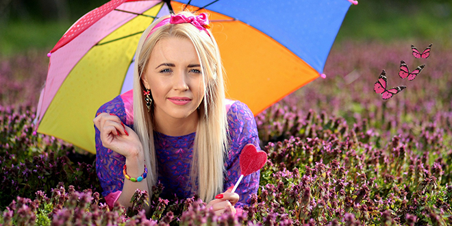 Девојка лежи и држи кишобран у руци