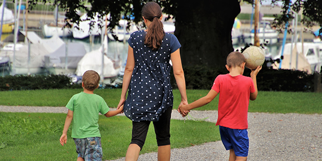 Мајка шета са својим синовима у парку