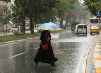 Данас хладно са падавинама, престанак кише и снега у другом делу дана Киша, жена прелази улицу и носи кишобран