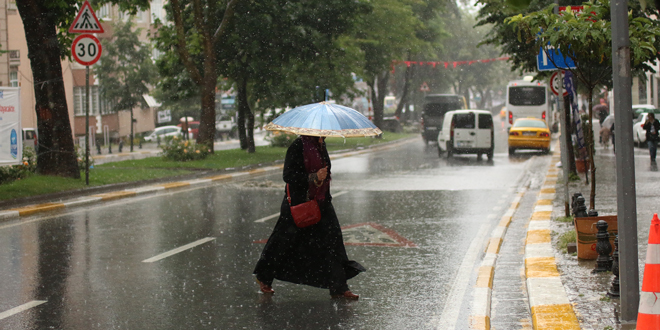 Киша, жена прелази улицу и носи кишобран Киша, жена прелази улицу и носи кишобран