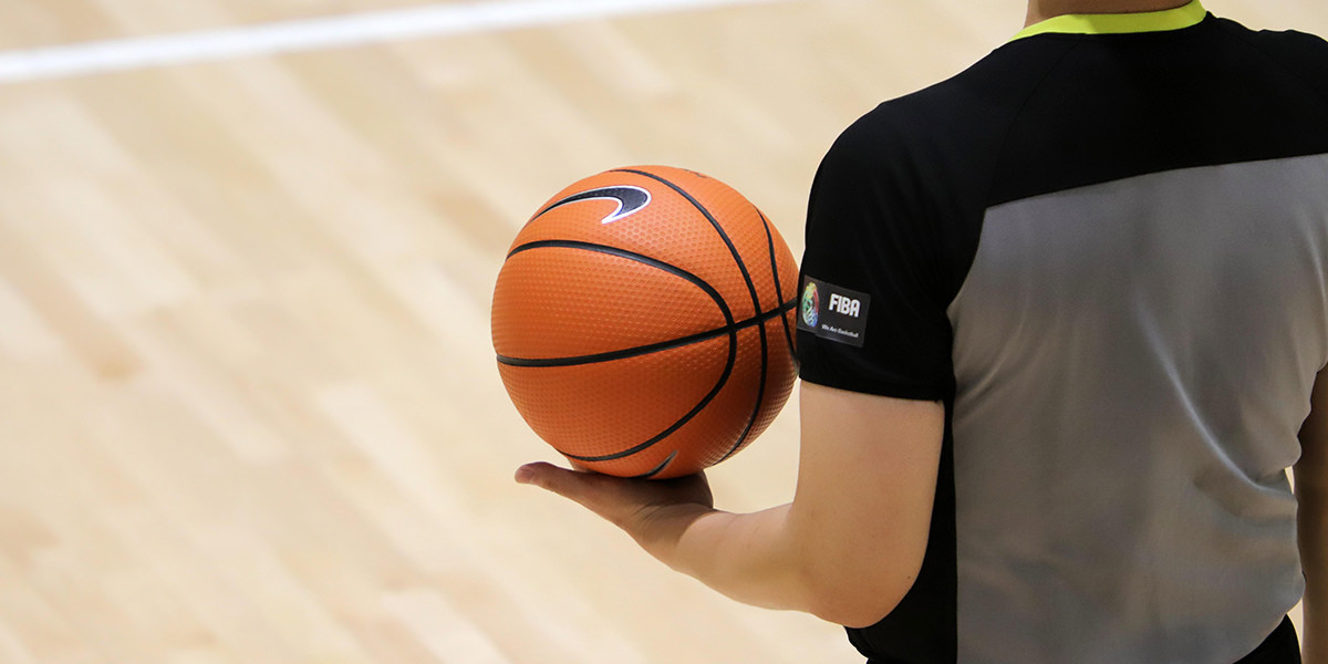 Судија држи кошаркашку лопту