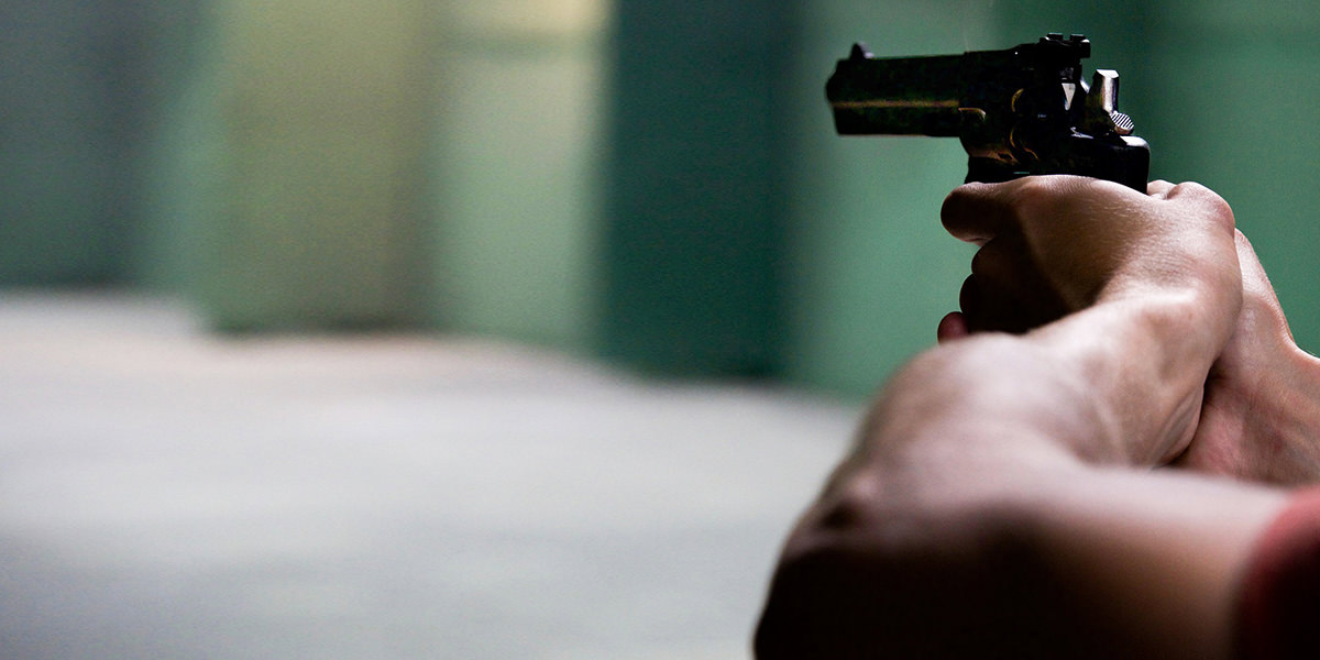 Мушкарац држи пиштољ