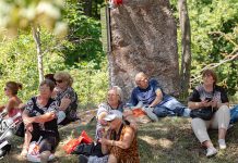 Сунчано и веома топло, уз ветар Старији људи седе у хладу