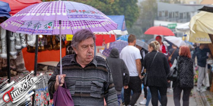 Мушкарац носи кишобран, киша